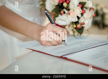 Dnepropetrovsk, Ucraina - 07.07.2017: Cerimonia nuziale. La coppia di nozze lascia le loro firme. La mano della sposa. Foto Stock