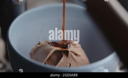 Preparazione di un affogato con gelato al cioccolato in tazza blu, foto ampia Foto Stock