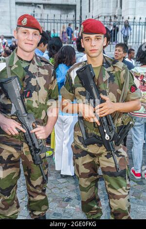 Parigi Francia,18° arrondissement Montmatre Soldiers Military,camouflage uniforms red beret FAMAS assalto fucili uomo maschio, Foto Stock