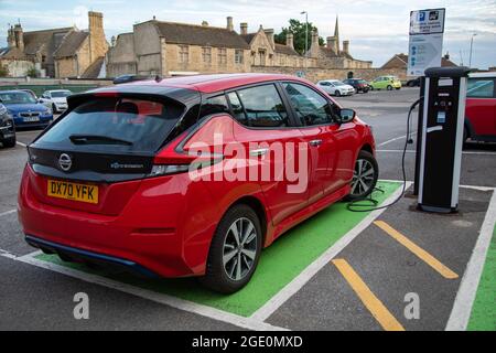 Nissan Leaf Charging nel parcheggio pubblico Foto Stock