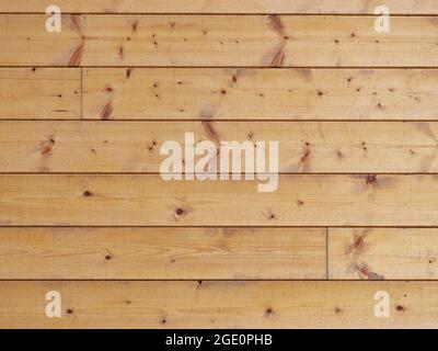 Vista su tavole di legno affilate nel muro di legno della cabina. Tavole di abete smaltate unite con linguetta e scanalatura Foto Stock