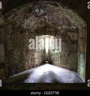 Luce che splende attraverso una sottile fessura di una finestra del castello Foto Stock