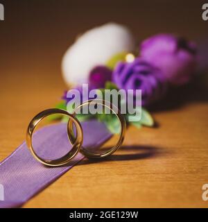 Anelli di fidanzamento di nozze sullo sfondo di un bouquet decorativo primo piano Foto Stock