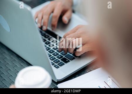 uomo d'affari lavora su un portatile con dati finanziari. Foto Stock