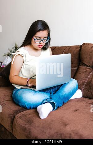 Donna teenager messicana con sindrome di Down che studia sul computer a casa, nel concetto di disabilità in America Latina Foto Stock