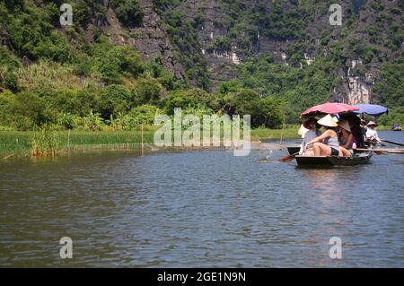 I vietnamiti e i viaggiatori stranieri viaggiano visita e gita in barca Tam Coc Bich Dong o Halong Bay sulla terra e Ngo fiume Dong e grotta di limesto Foto Stock