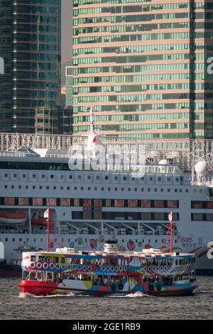 La 'Night Star', una delle flotte Star Ferry, attraversa Victoria Harbour da Tsim Sha Tsui, Kowloon, al centro sull'Isola di Hong Kong Foto Stock