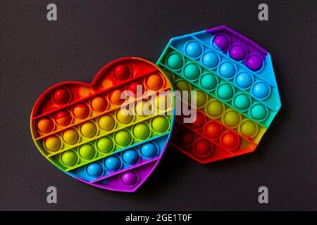Colorful antistress sensoriale giocattolo fidget spingere pop esso su sfondo nero Foto Stock