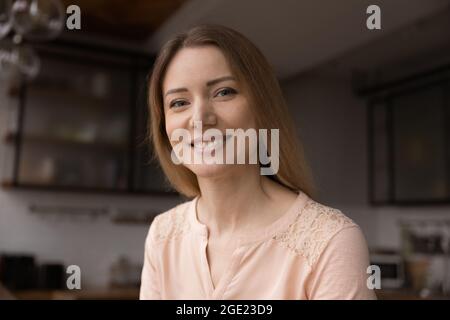 Headshot ritratto giovane donna sorriso guarda la fotocamera Foto Stock