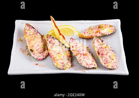 Le cozze kiwi, note anche come verdi, verdi-lipped, giganti e Nuova Zelanda, cotte al forno con salsa al formaggio, peperone, parmigiano, roe di pesce volante tobiko. Foto Stock