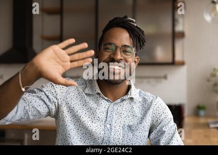 Bel ragazzo africano wave mano saluto amico avviare videoconferenza Foto Stock