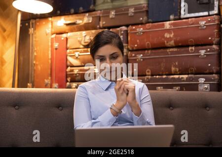Un dipendente indiano serio e preoccupato guarda lo schermo del notebook Foto Stock