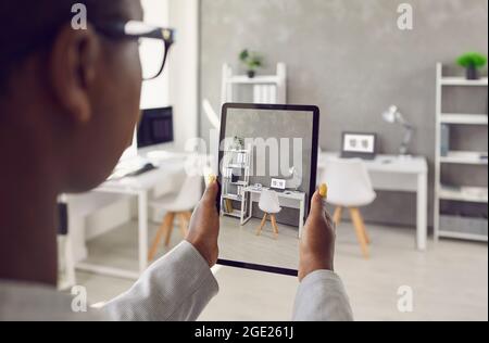 Donna che scatta foto o video dell'interno dello spazio di lavoro in un nuovo ufficio o appartamento Foto Stock