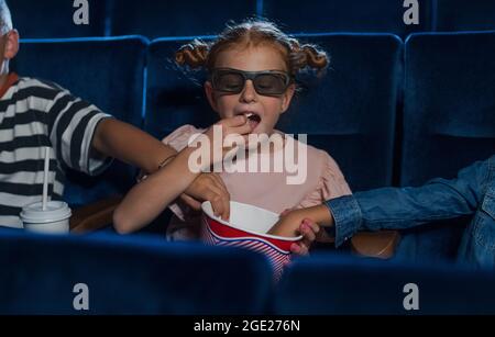 Felici i bambini con occhiali 3d al cinema, guardando film e mangiando popcorn. Foto Stock