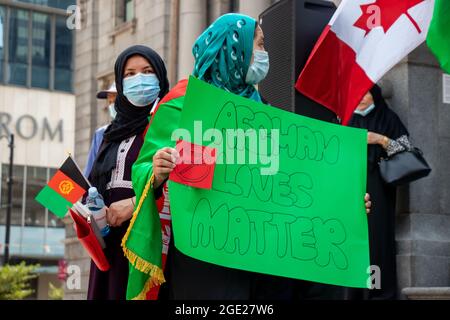 Vancouver, Canada - Agosto 14,2021: La donna sta tenendo un segno Afghan Lives Matter, Stop Terrorism al di fuori della Vancouver Art Gallery Foto Stock