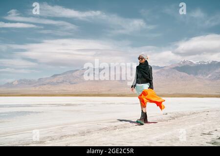 donna asiatica turista femminile in gonna lunga che cammina su terra salina alcalina Foto Stock