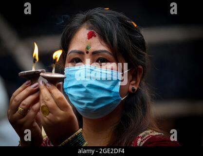 Kathmandu, Bagmati, Nepal. 16 agosto 2021. Una donna nepalese prega su Shrawan Somvar in un tempio di Shiva in mezzo all'epidemia di COVID-19 a Kathmandu, capitale del Nepal il 16 agosto 2021. Lunedì o Somvars del mese santo Shrawan sono considerati favorevoli come la gente veloce ed offrire le preghiere al Signore Shiva, specialmente le donne digiunano & pregano per una vita prospera e lunga dei loro mariti o desiderano trovarne una buona. (Credit Image: © Sunil Sharma/ZUMA Press Wire) Credit: ZUMA Press, Inc./Alamy Live News Foto Stock