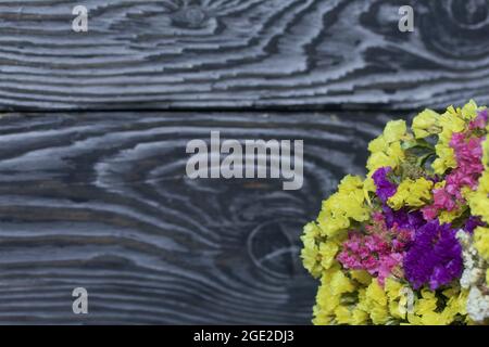 Bouquet di fiori di colori diversi. Sullo sfondo di tavole di pino. Primo piano. Foto Stock