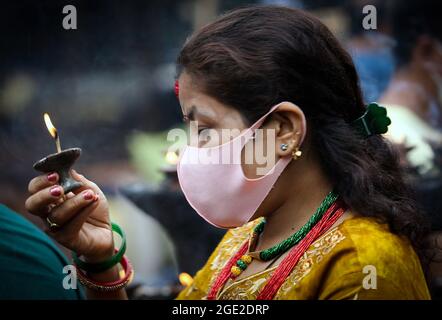 Kathmandu, Bagmati, Nepal. 16 agosto 2021. Una donna nepalese prega su Shrawan Somvar in un tempio di Shiva in mezzo all'epidemia di COVID-19 a Kathmandu, capitale del Nepal il 16 agosto 2021. Lunedì o Somvars del mese santo Shrawan sono considerati favorevoli come la gente veloce ed offrire le preghiere al Signore Shiva, specialmente le donne digiunano & pregano per una vita prospera e lunga dei loro mariti o desiderano trovarne una buona. (Credit Image: © Sunil Sharma/ZUMA Press Wire) Credit: ZUMA Press, Inc./Alamy Live News Foto Stock