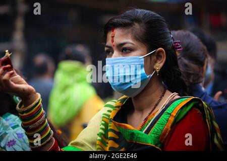 Kathmandu, Bagmati, Nepal. 16 agosto 2021. Una donna nepalese prega su Shrawan Somvar in un tempio di Shiva in mezzo all'epidemia di COVID-19 a Kathmandu, capitale del Nepal il 16 agosto 2021. Lunedì o Somvars del mese santo Shrawan sono considerati favorevoli come la gente veloce ed offrire le preghiere al Signore Shiva, specialmente le donne digiunano & pregano per una vita prospera e lunga dei loro mariti o desiderano trovarne una buona. (Credit Image: © Sunil Sharma/ZUMA Press Wire) Credit: ZUMA Press, Inc./Alamy Live News Foto Stock