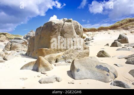 Herm, Channel Islands, UK - 2 luglio 2016: Massi di granito sulla spiaggia di Mouisonnière sotto l'Obelisco, resti della cava durante l'Ottocento. Foto Stock