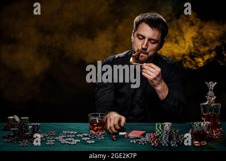 Uomo giocatore di casinò bearded che gioca a poker su tavolo verde Foto Stock