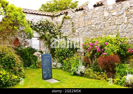 Herm, Isole del canale, Regno Unito - 1 luglio 2016: pietra commemorativa per Jenny e Peter Wood nel cortile della chiesa del Manor Village. Foto Stock