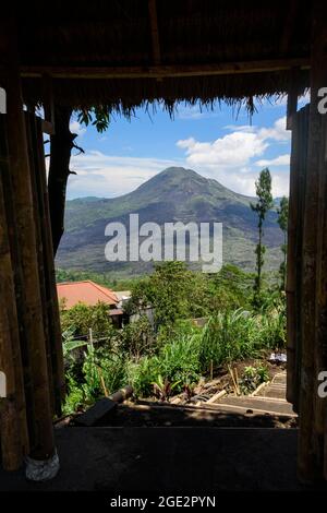 Vista del vulcano attivo Monte (Gunung) Batur visto da una porta aperta. Bali, Indonesia. Foto Stock