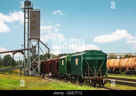 Carro ferroviario di carico in piedi vicino all'ascensore nella zona agricola. Grano silo, magazzino o deposito è una parte importante di raccolta Foto Stock