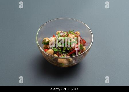 lobio georgiano o insalata con fagioli, cipolla, peperone e verdure in un recipiente di vetro Foto Stock