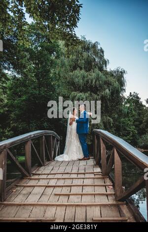 Bella sposa in elegante abito da sposa bianco con velo lungo e sposo in abito blu Foto Stock