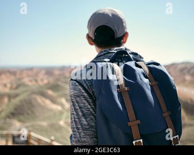 vista posteriore di un uomo asiatico turista zaino in spalla maschile guardando le forme yardang nel parco geologico nazionale Foto Stock