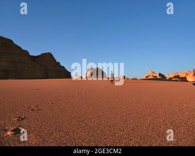 vista posteriore della donna asiatica turistica a piedi nel parco geologico nazionale vicino a dunhuang, provincia di gansu, cina Foto Stock