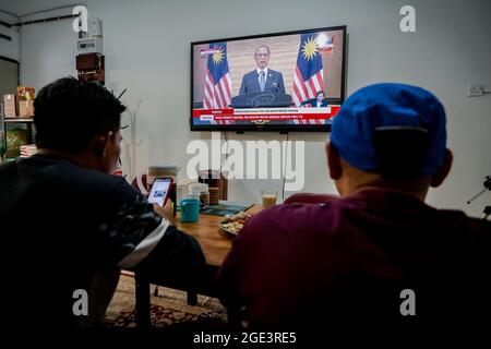 Kuala Lumpur, Malesia. 16 agosto 2021. La gente guarda il discorso del primo ministro Muhyiddin Yassin su uno schermo televisivo a Kuala Lumpur.il primo ministro malese Muhyiddin Yassin ha annunciato le sue dimissioni durante una conferenza stampa ufficiale presso l'ufficio del primo ministro (PMO) a Putrajaya. (Foto di Syaful Redzuan/SOPA Images/Sipa USA) Credit: Sipa USA/Alamy Live News Foto Stock