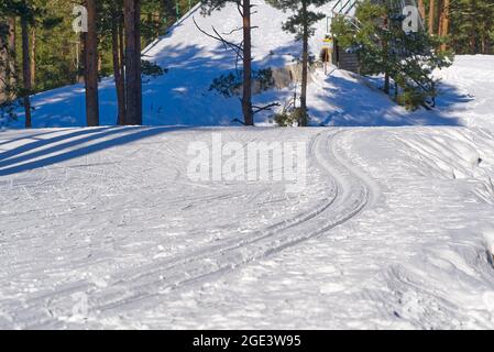 Piste da sci di fondo sulla neve nel giorno del suny. Camion per lo sci invernale Foto Stock