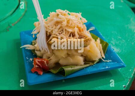 Cibo tradizionale a Granada, Nicaragua. Si chiama tonigine - yucca con pelle di maiale fritta e salice. Foto Stock