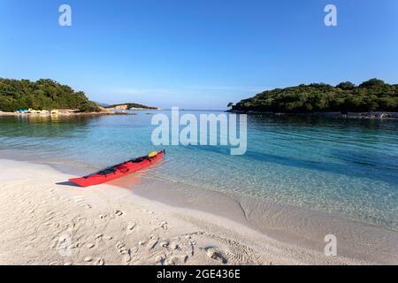 Kayak di mare rosso su una bella spiaggia di sabbia solitaria in estate mattina, Ksamil, Mar Ionio, Albania Foto Stock
