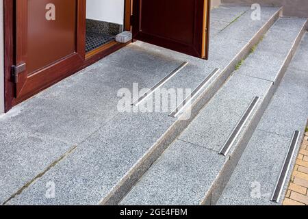 gradini con strisce antiscivolo in gomma sulla scala ad arco all'ingresso  dell'edificio in mattoni bianchi da vicino, nessuno Foto stock - Alamy