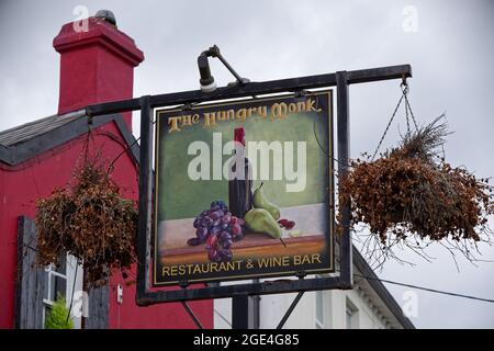 GREYSTONES, IRLANDA - 07 giu 2021: Un segno con un annuncio del ristorante Hungry Monk e wine bar nella città di Greystones, County Wicklow, Irlanda. Foto Stock