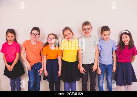 Bambini in uniforme colorata scuola su sfondo bianco Foto Stock