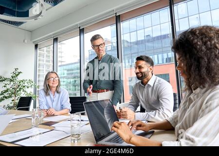 Il leader maschile del CEO parla con i partner al meeting in sala riunioni in un ufficio moderno. Foto Stock