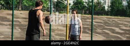 Uomini che giocano a basket sul campo, banner Foto Stock
