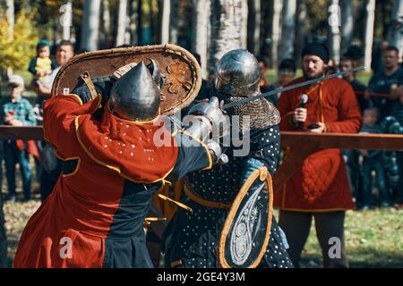 Una battaglia epica di cavalieri in armatura e caschi. Lotta con la spada. Ricostruzione di battaglie medievali. Festival della cultura medievale. Bishkek, Kirghizistan - 13 ottobre 2019 Foto Stock