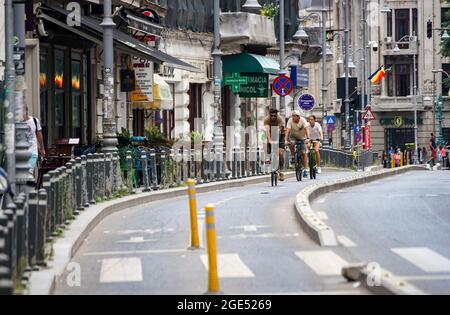Bucarest, Romania - 12 agosto 2021: La gente guida le biciclette sulla pista ciclabile di Victory Avenue a Bucarest, Romania. Questa immagine è per uso editoriale Foto Stock