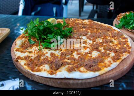 Pizza turca al lahmacun. Lahmajun con erbe e limone. Cucina tradizionale turca. Foto Stock