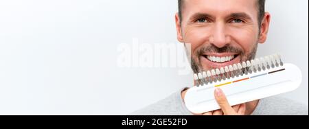 Sbiancamento dei denti, sorriso bianco perfetto. Uomo sorridente con guida sbiancante Foto Stock