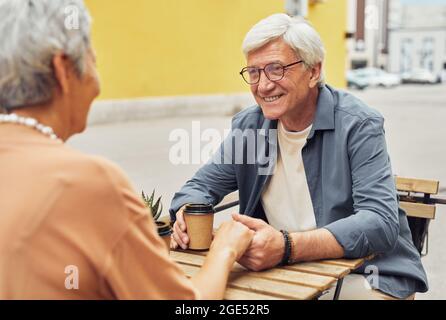 Ritratto di una coppia anziana moderna che gode di un appuntamento romantico in un caffè all'aperto durante le vacanze estive Foto Stock