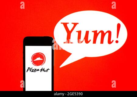 In questa illustrazione fotografica, un logo Pizza Hut visualizzato su uno smartphone con un Yum! Logo dei marchi sullo sfondo. Foto Stock