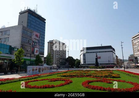 NIS, Serbia - 14 agosto 2021 Piazza nel centro della città di NIS e bellissimo parco con fiori rossi in una giornata estiva di sole Foto Stock