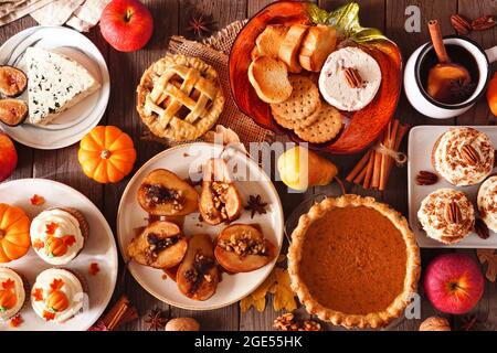 Concetto di cibo autunnale. Selezione di torte, antipasti e dessert. Tavolo con vista dall'alto su uno sfondo rustico in legno. Foto Stock